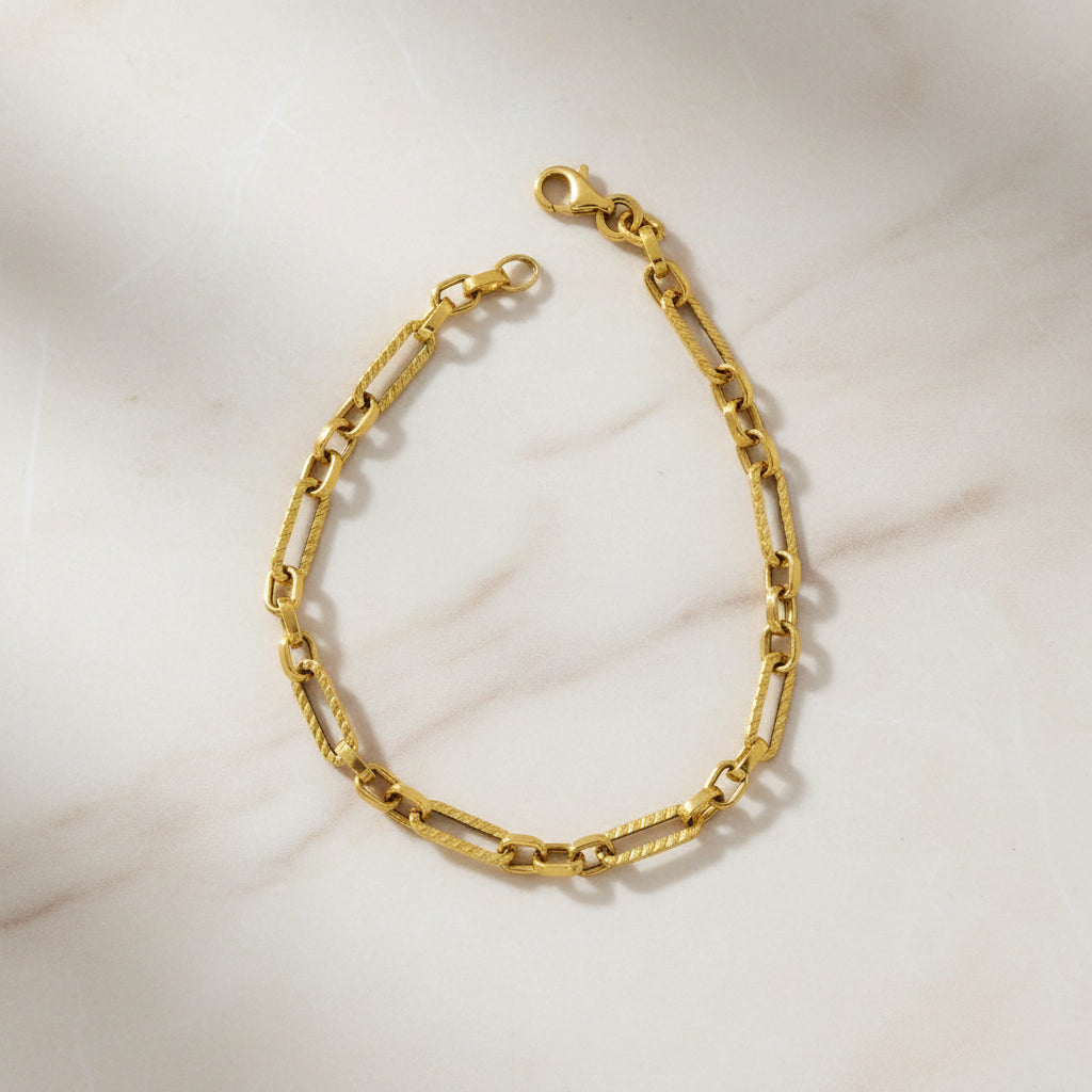 Goldenes Armband mit länglichen, strukturierten Kettengliedern in abwechselnder Form und Karabinerverschluss, im klassischen Kettendesign.