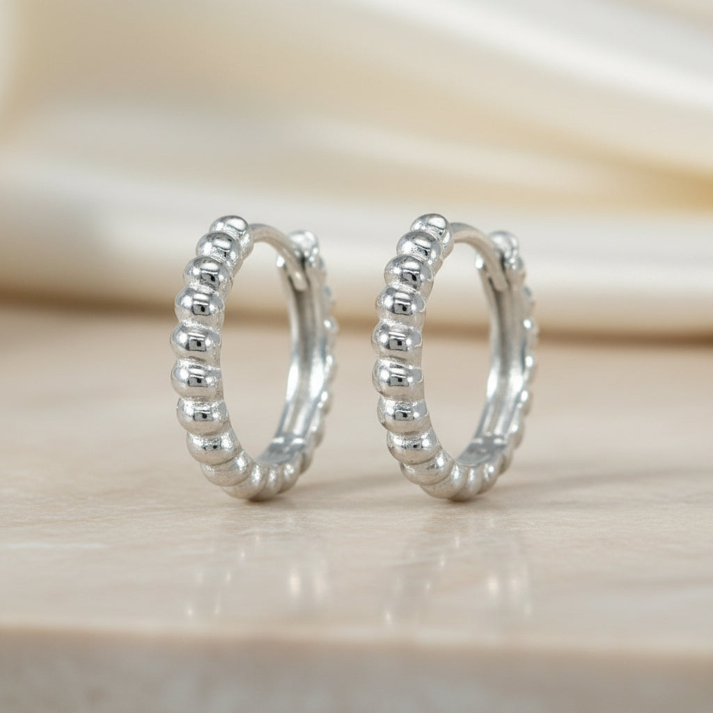 Kleine Creolen aus rhodiniertem 925er Silber mit umlaufender feiner Kugelstruktur im Bead-Design.