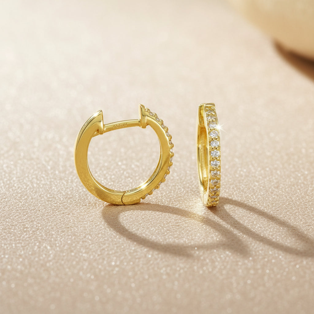 Creole aus Gelbgold mit sichtbarer Brillantreihe, einmal frontal und einmal seitlich dargestellt.