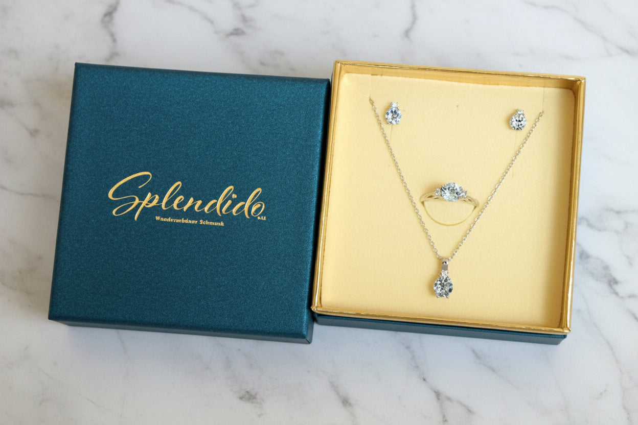 Geschenkverpackung von Splendido in Türkis mit goldfarbenem Innenfutter und Schmuckset aus Kette, Ring und Ohrsteckern
