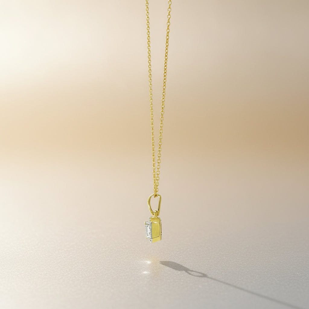 Collier K69 aus Gelbgold mit oktagonalem Mittelstein und funkelnder Diamantumrahmung, seitlich fotografiert.