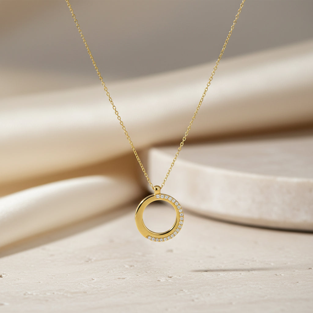 Kette aus Gelbgold mit rundem, teilmattiertem Kreis-Anhänger, verziert mit einer Linie funkelnder Brillanten (0,12 ct), frontal dargestellt.