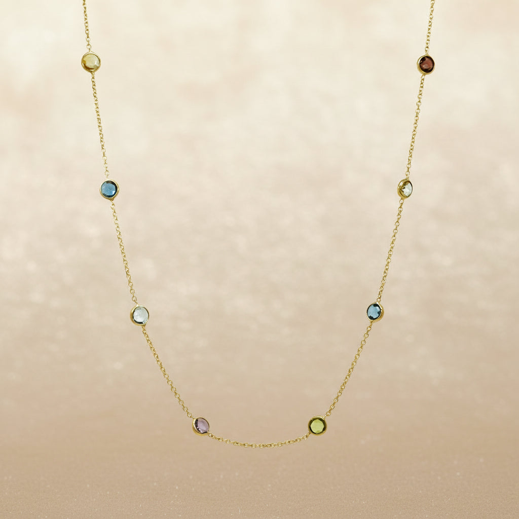 Zarte Goldkette mit rund eingefassten, verschiedenfarbigen Edelsteinen: Granat, Amethyst, London Topas, Peridot, Topas und Citrin.