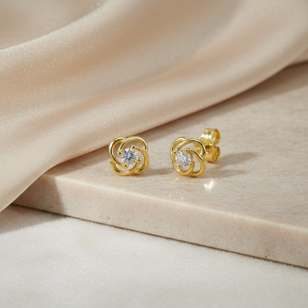 Gelbgoldene Ohrstecker in Knotenform mit zentralem Zirkonia