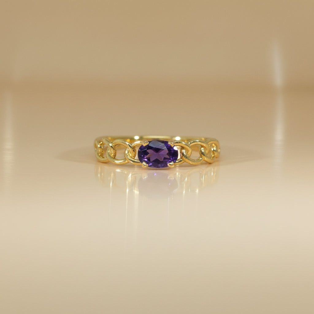Gelbgoldring mit oval facettiertem Amethyst und dekorativer, kettenartiger Ringschiene, frontal dargestellt.