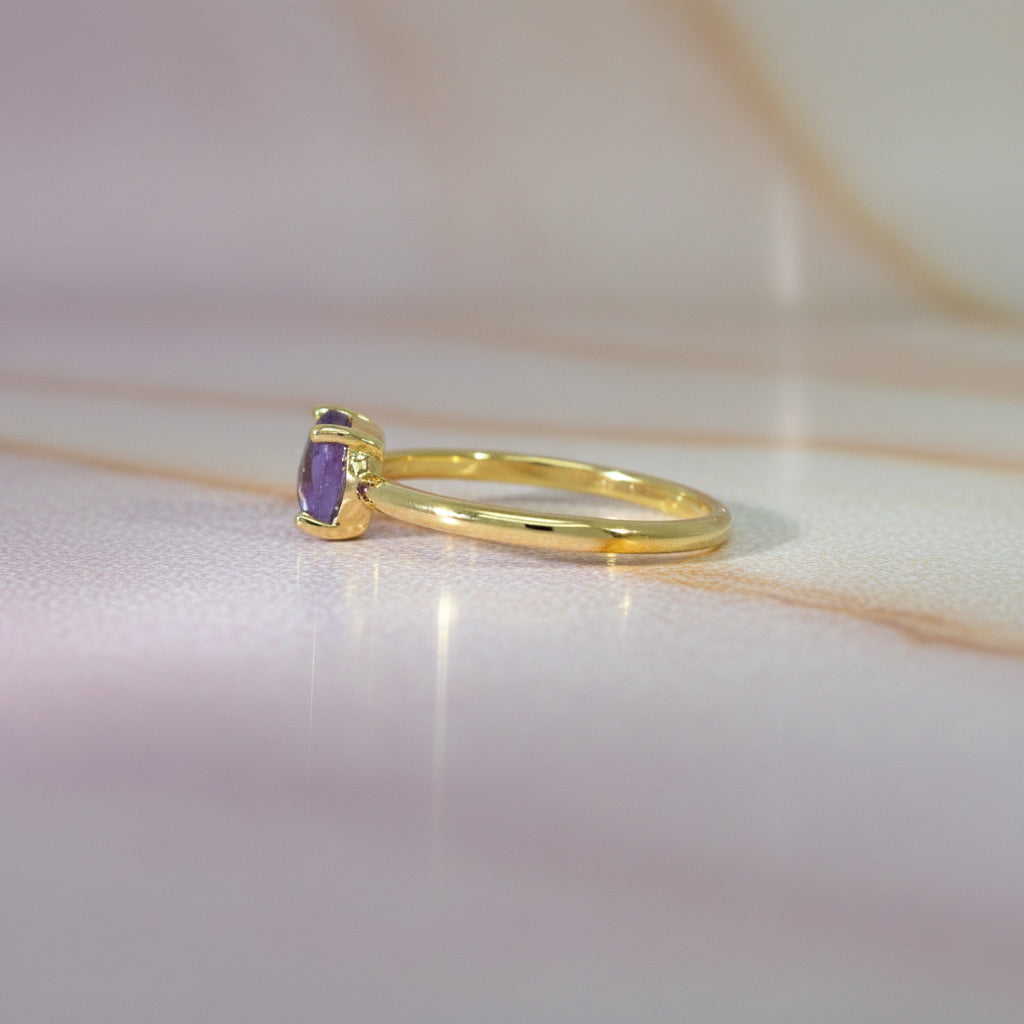 Feiner Gelbgoldring im Profil, der runde Amethyst-Stein sitzt erhöht in einer schlanken Krappenfassung.