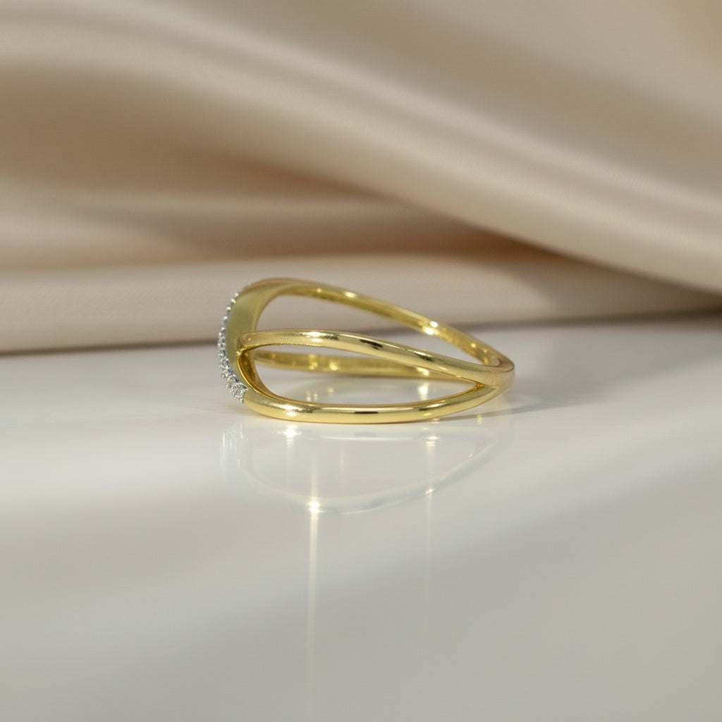 Seitliche Ansicht des Gelbgoldrings R46 mit geschwungener, gekreuzter Ringschiene und pavégefasster Brillantlinie.