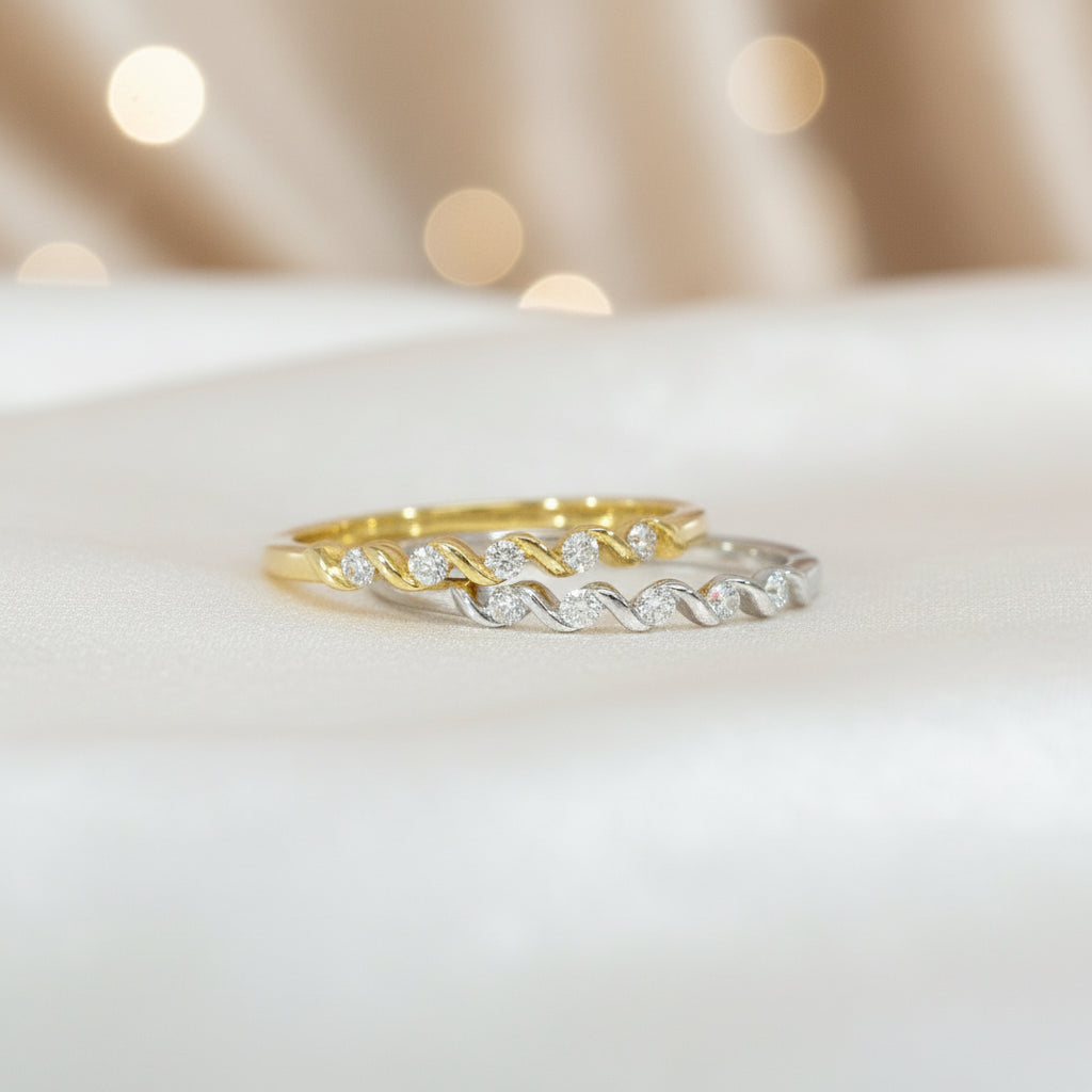 Zwei R49-Ringe in Gelb- und Weißgold nebeneinander, beide mit funkelnder Brillantreihe in gedrehter Optik.