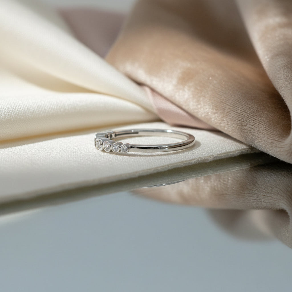 Weißgoldring mit abgestufter Reihe rund eingefasster Brillanten (insgesamt 0,25 ct) entlang der Vorderseite, frontal dargestellt.