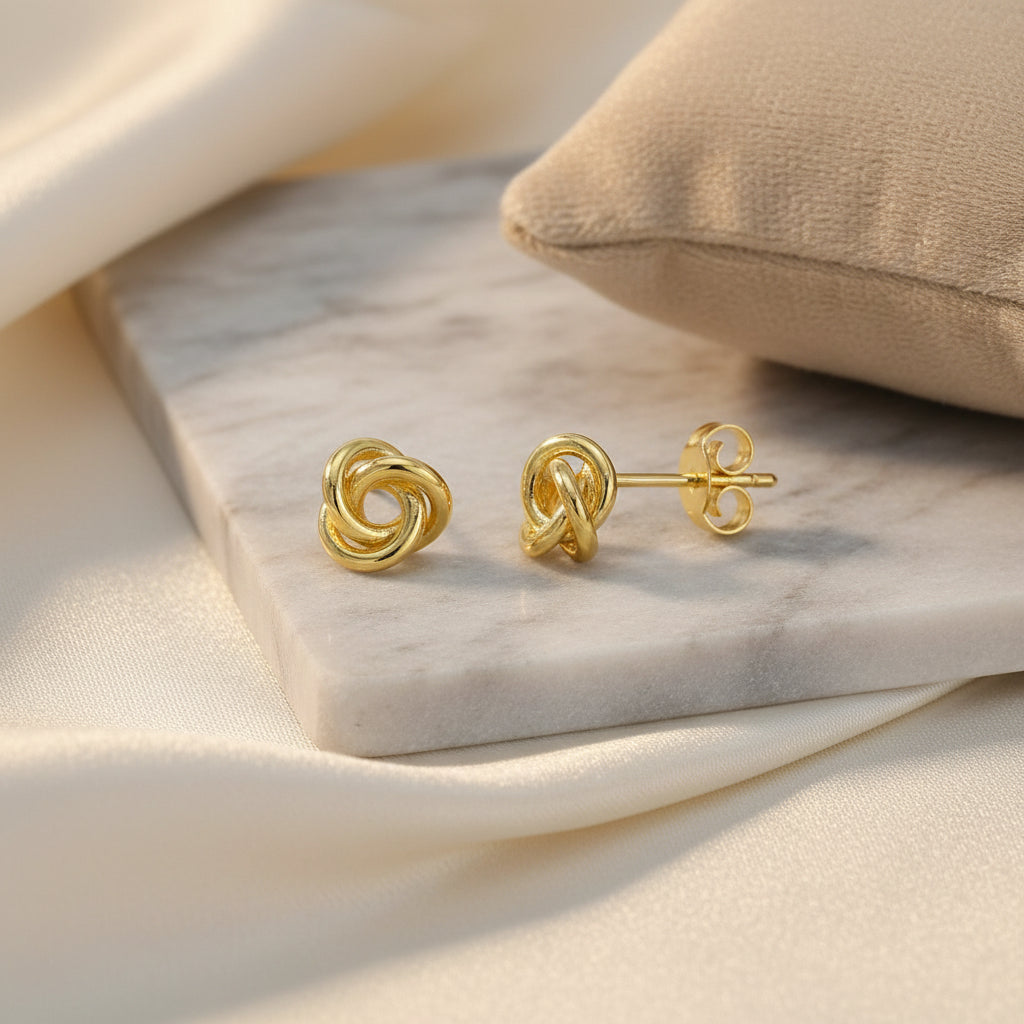 Vergoldete Ohrstecker mit einem verschlungenen Knoten-Design.