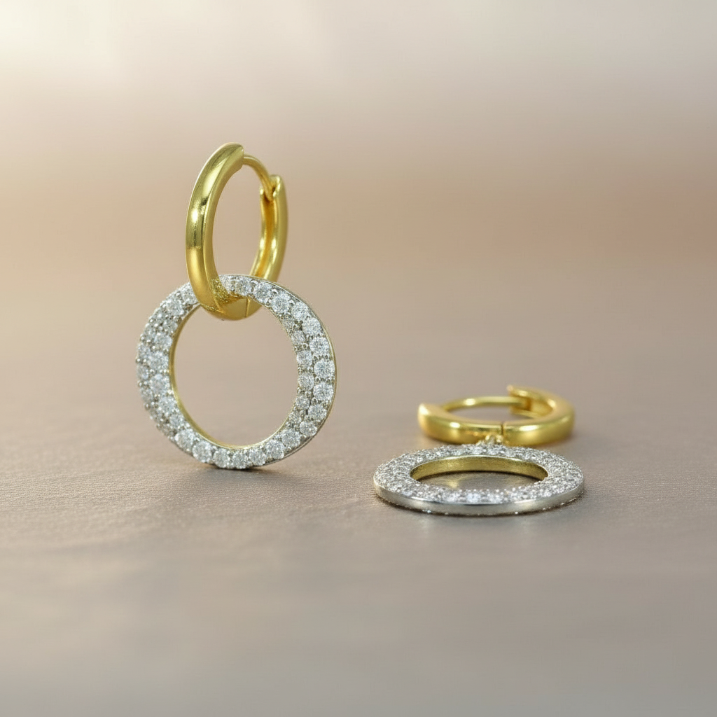 Elegante goldfarbene Huggie-Ohrringe mit beweglichem, dicht mit klaren Zirkonia-Steinen besetztem Ringanhänger.