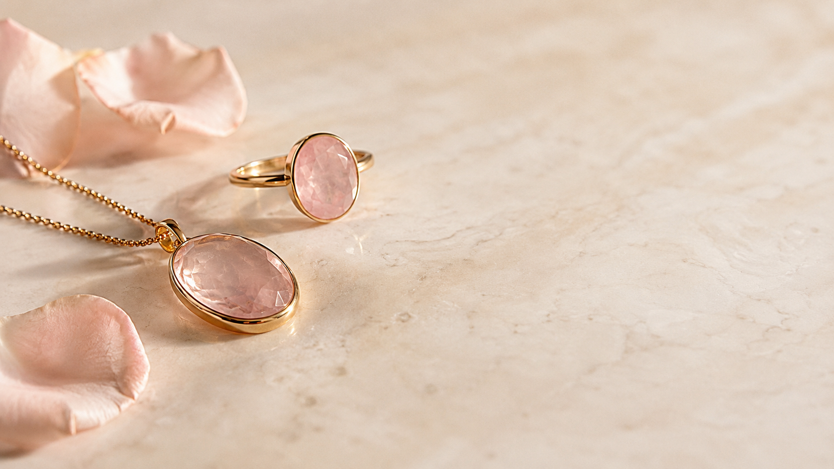 Zartrosa Rosenquarz-Schmuckstein in goldener Fassung auf hellem Marmor — Splendido Schmuck