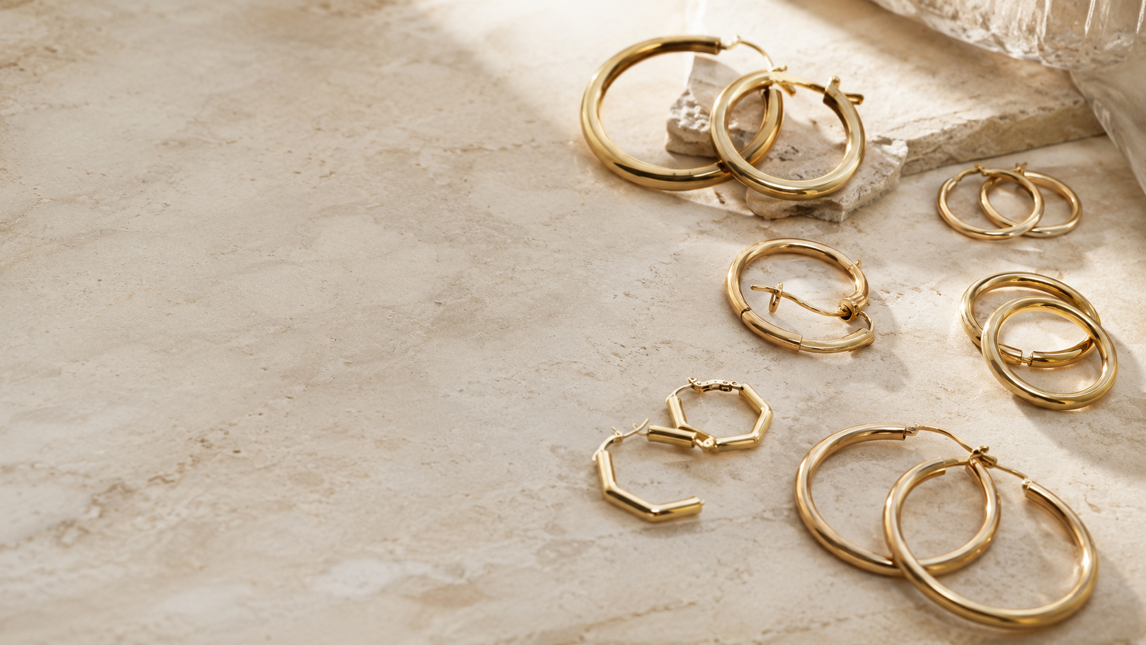 Frau mit goldenen Creolen am Ohr, warmes Studiolicht — Splendido Schmuck