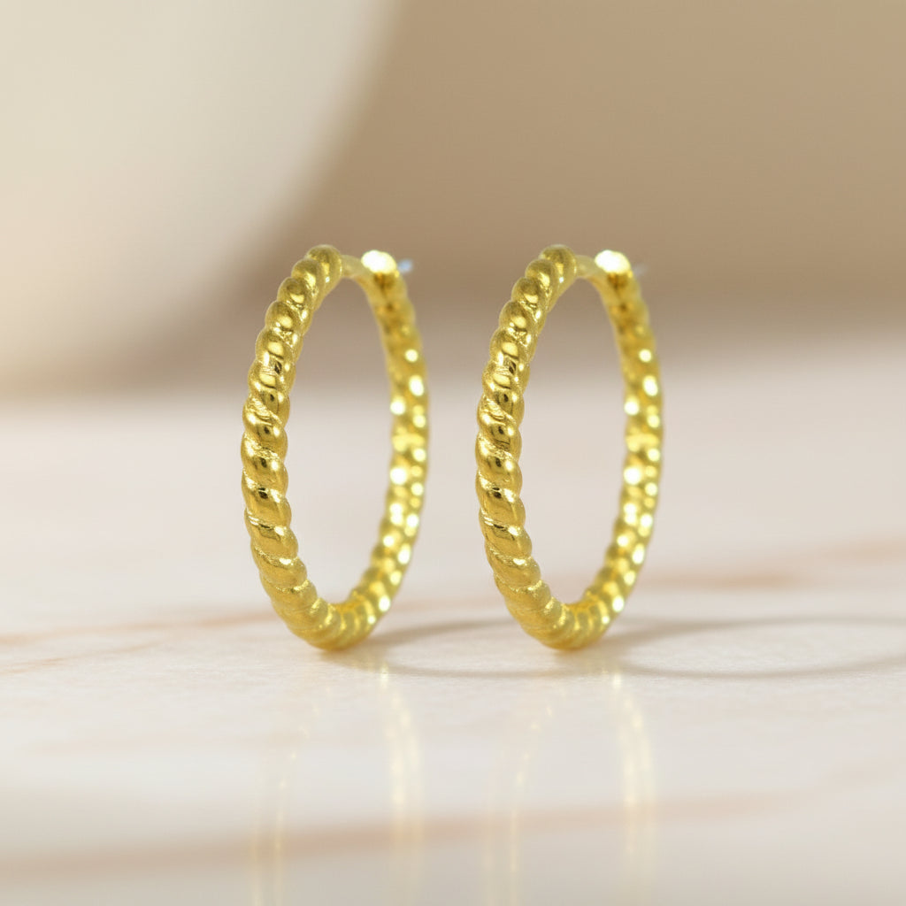 Zarte Creolen aus gelb vergoldetem 925er Silber mit rundumlaufender, gedrehter Struktur.