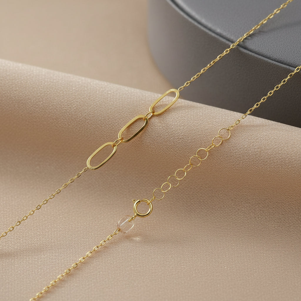 Detailaufnahme des Verschlusses und der ovalen Glieder der Goldkette

