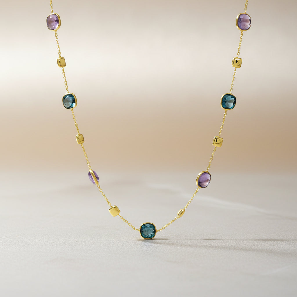 Kette aus Gelbgold, besetzt mit abwechselnd eingefassten quadratischen London Blue Topas und Amethyst Steinen sowie kleinen polierten Goldelementen.

