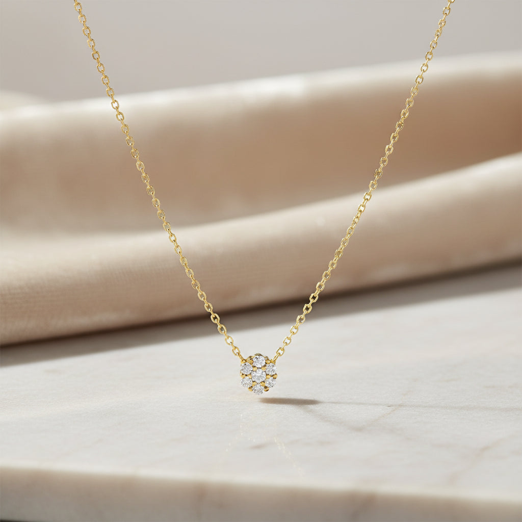 Kette aus Gelbgold mit floralem Zirkonia-Anhänger, Blütenform, frontal gezeigt.