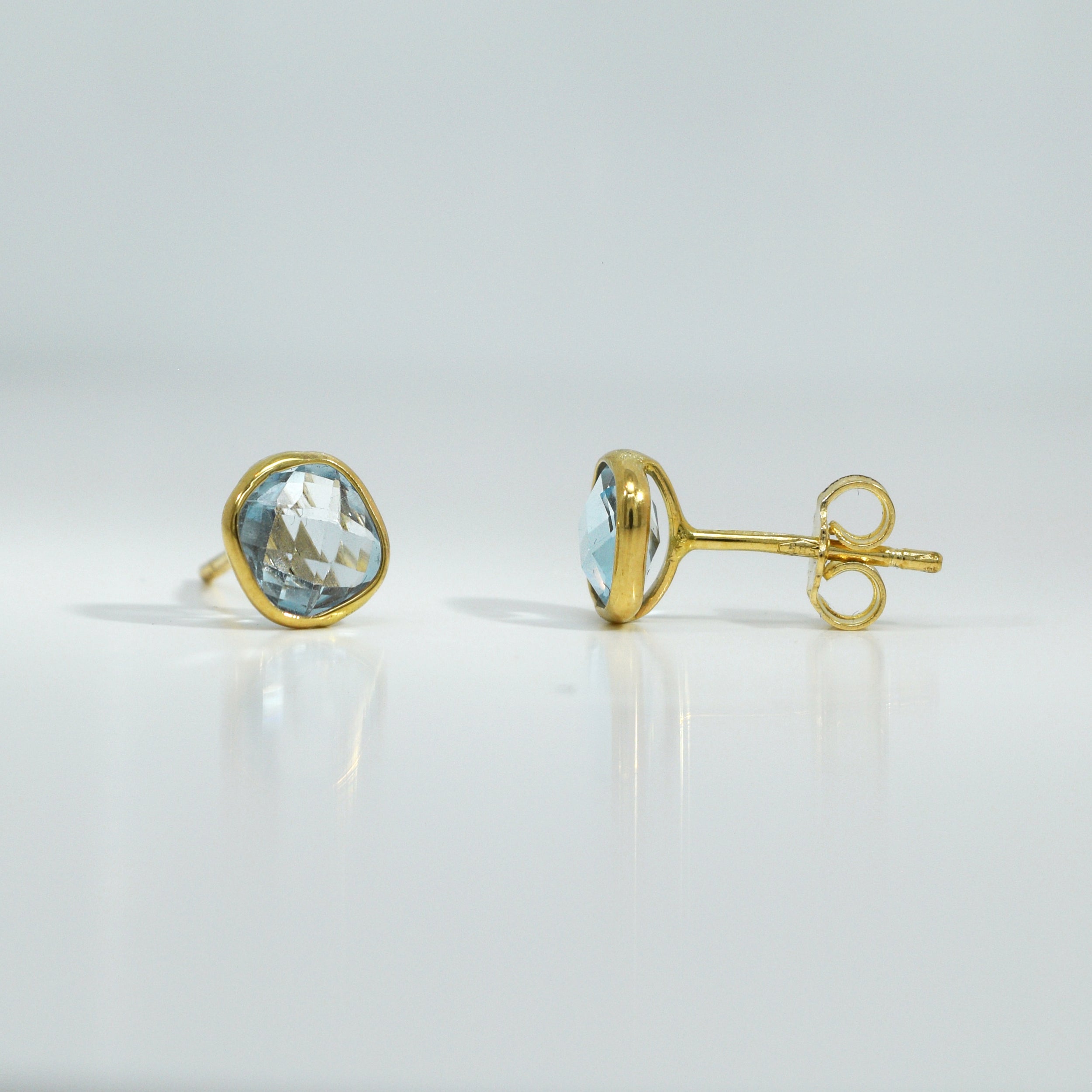 Ohrstecker mit hellblauem Topas in Zargenfassung aus Gelbgold


