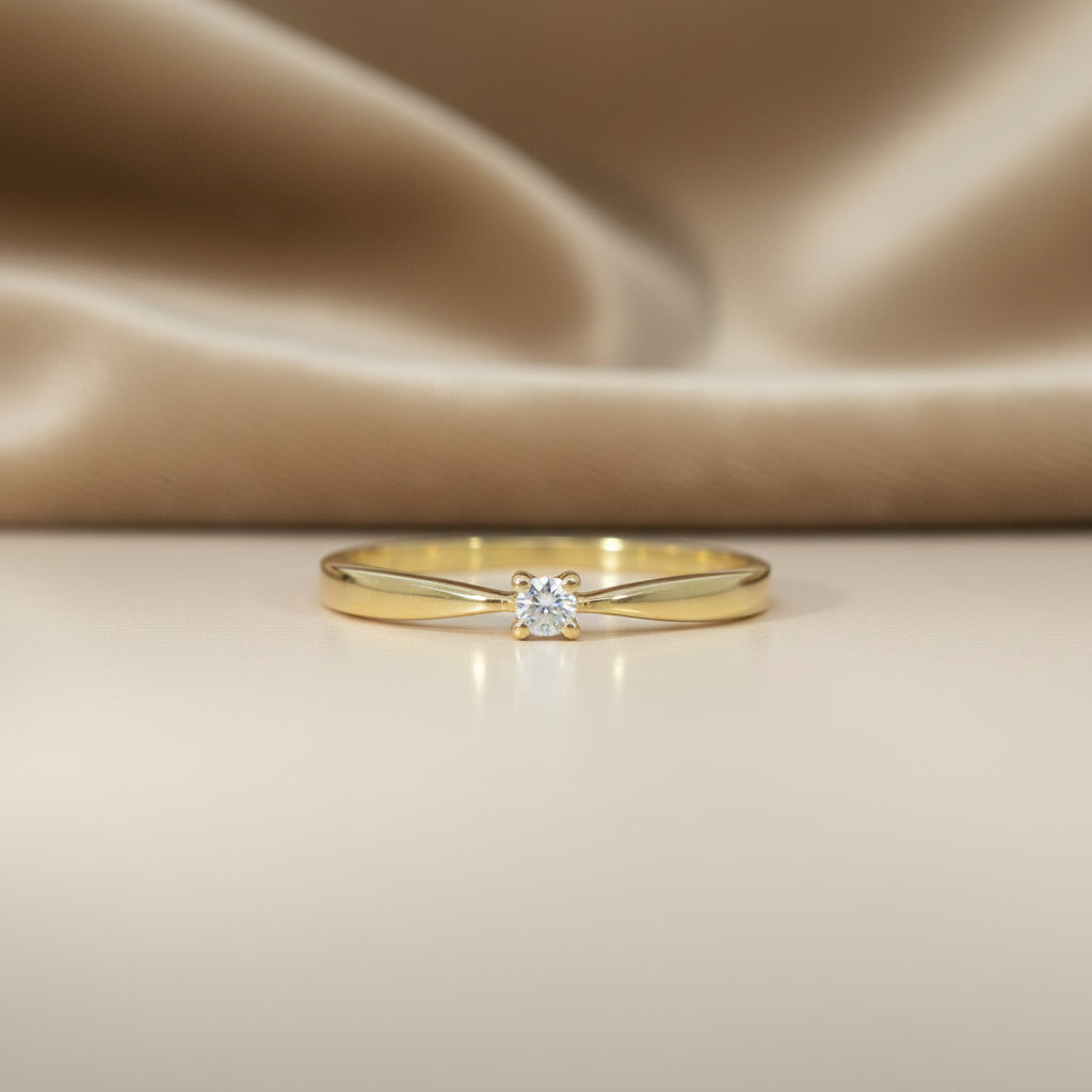 Zarter Gelbgoldring mit kleinem runden Brillantsolitär von 0,05 ct in vier Krappen, frontal aufgenommen.