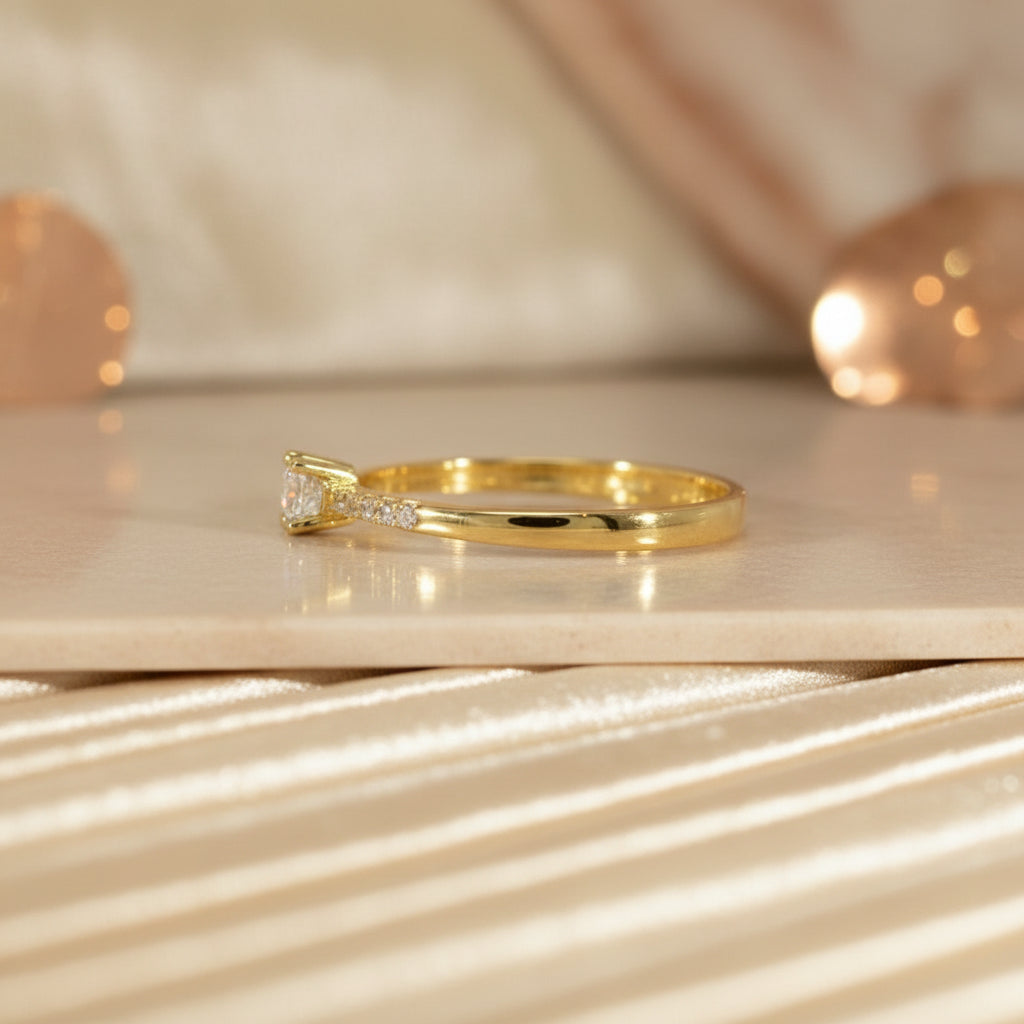 Seitliche Ansicht des Gelbgoldrings RZ9 mit erhöht gefasstem Zirkonia-Solitär und funkelnder Zirkonia-Reihe entlang der Ringschiene.