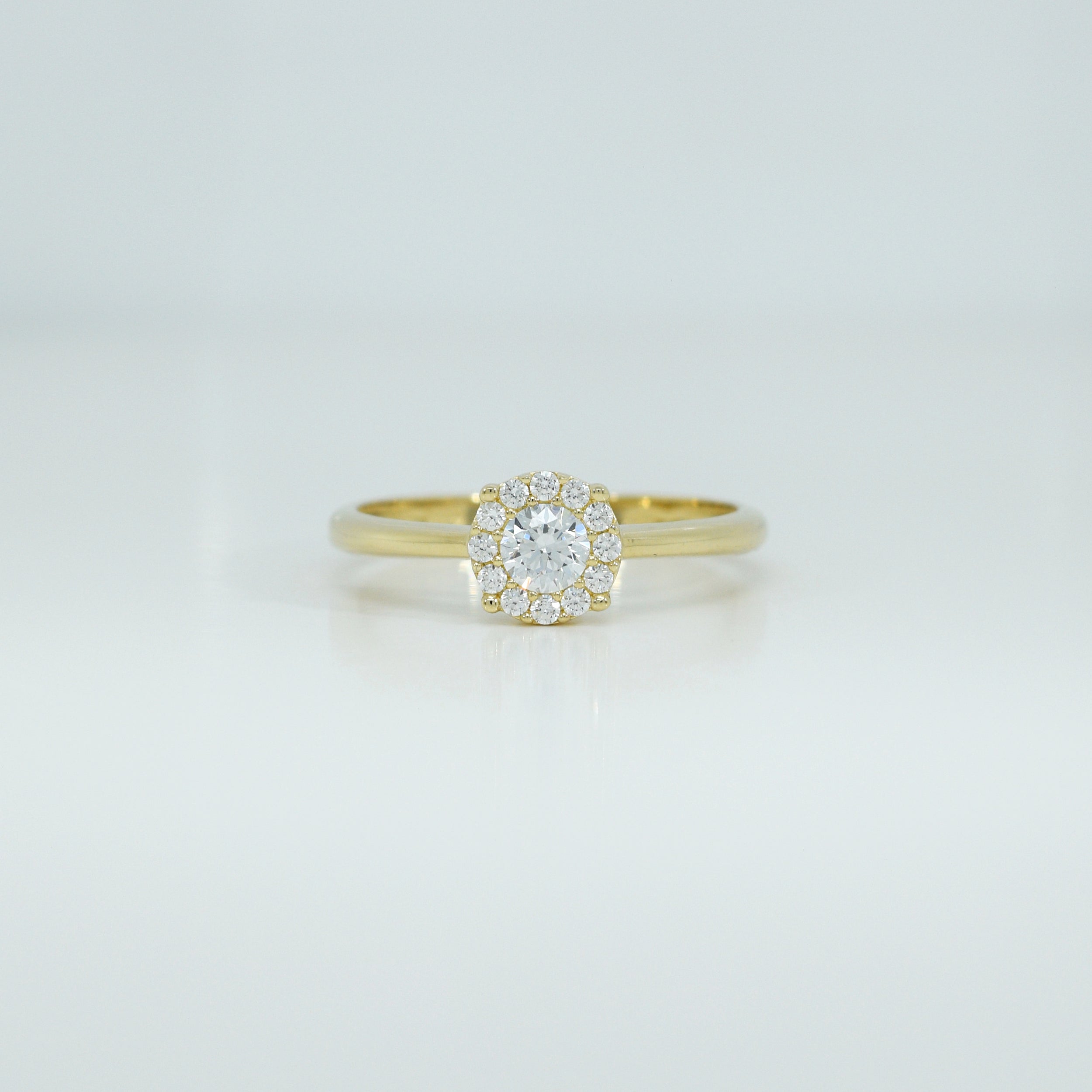 Gelbgoldener Ring, Modell RZ13, mit funkelndem Zirkonia-Solitär und Halo-Design, Frontalansicht.