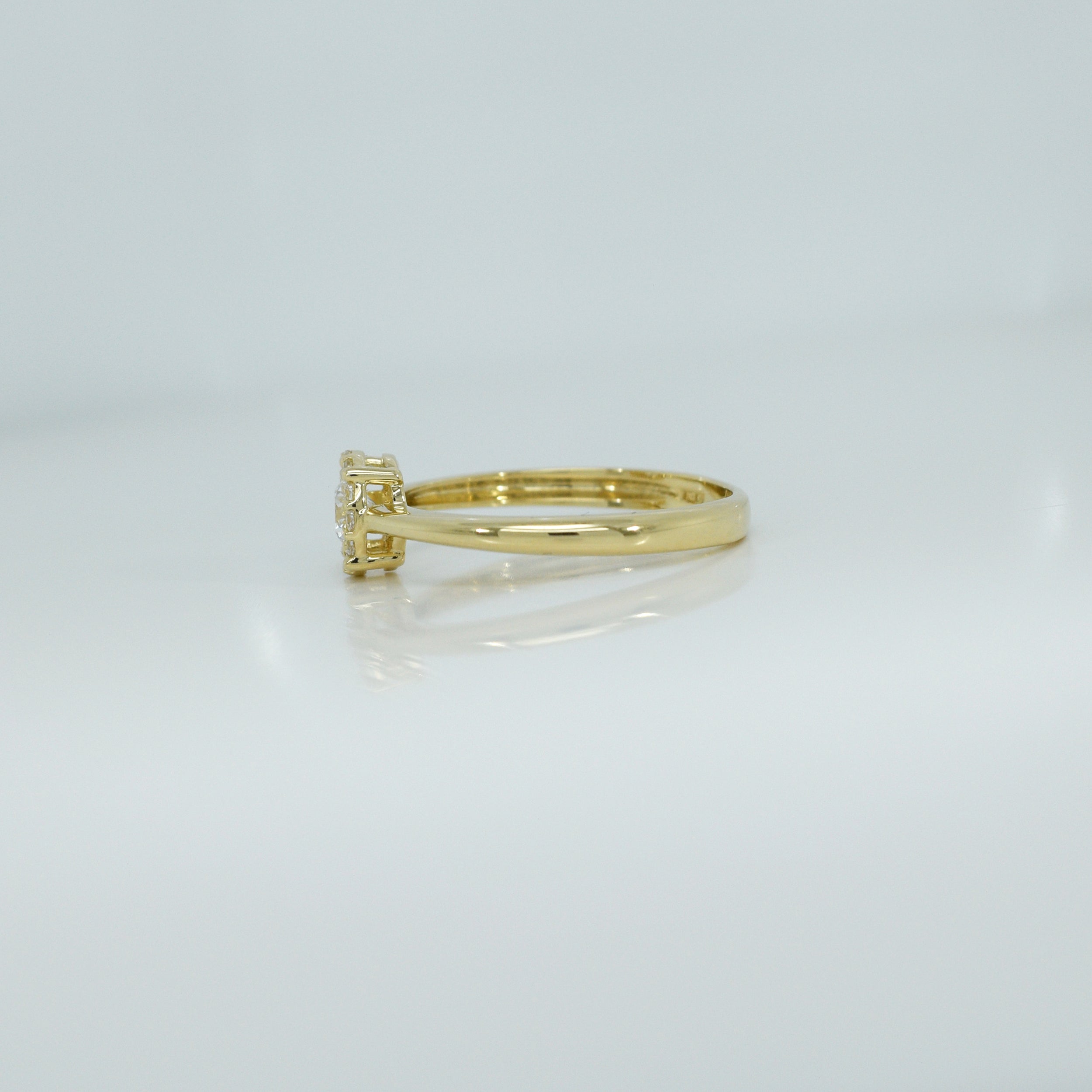 Zirkoniaring aus Gelbgold, Modell RZ13, seitliche Ansicht mit geschwungener Fassung und rundem Steinbesatz.
