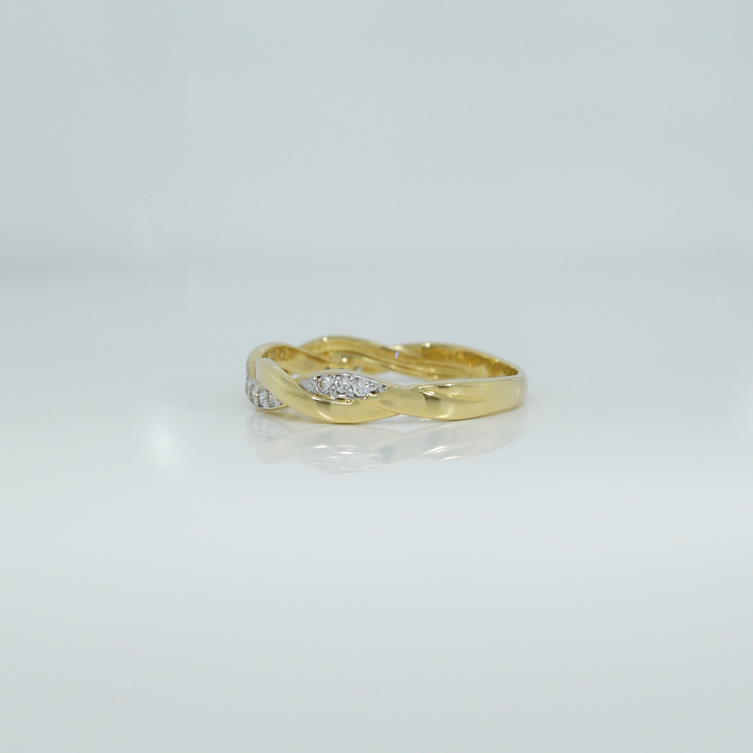 Gelbgoldener Ring, Modell RZ2, mit Zirkonia und elegantem, verschlungenem Band, Seitenansicht.

