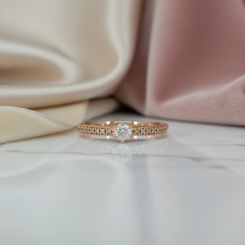 Zarter Roségoldring mit rundem Brillantsolitär (0,17 ct) und pavégefasster Schiene mit kleinen Brillanten (gesamt 0,22 ct), frontal aufgenommen.