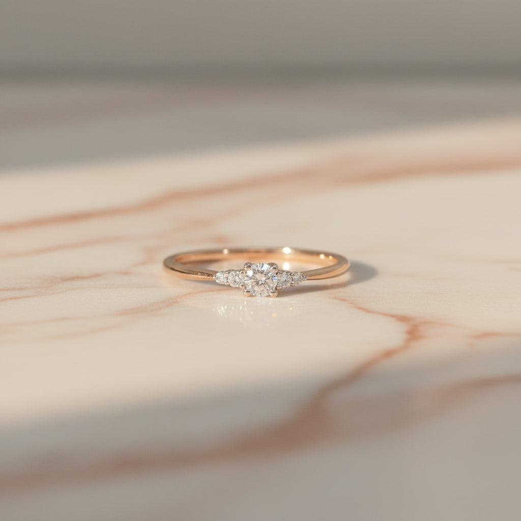 Feiner Roségoldring mit Brillantkomposition aus Mittelstein und seitlichen Diamanten (zusammen 0,15 ct), frontal dargestellt.