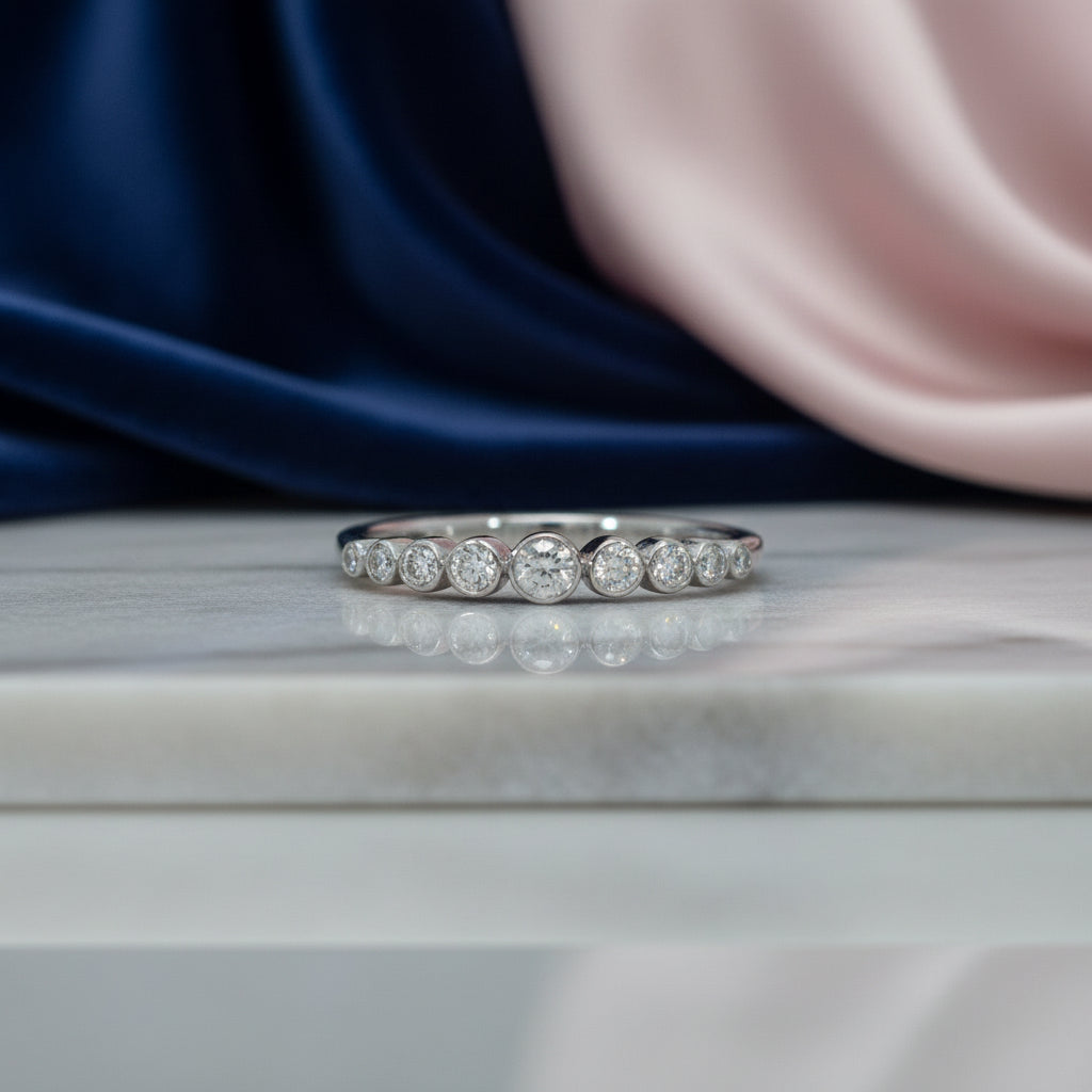 Weißgoldring mit abgestufter Reihe rund eingefasster Brillanten (insgesamt 0,25 ct) entlang der Vorderseite, frontal dargestellt.