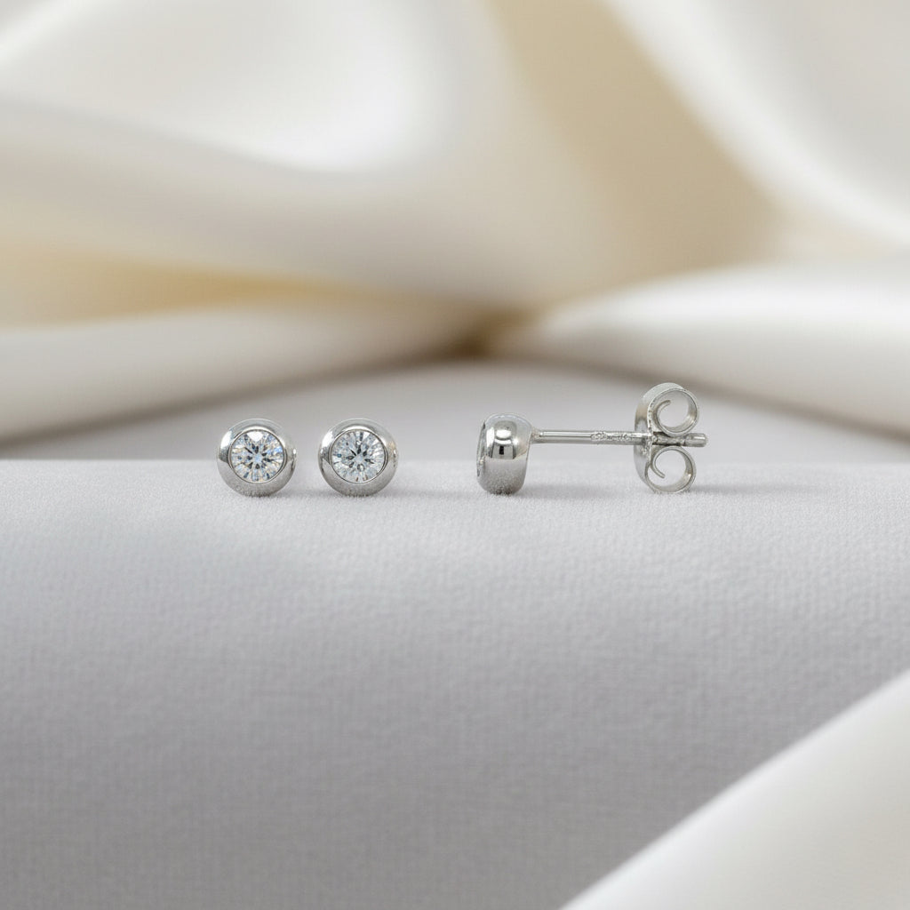 Silberne Ohrstecker mit einem runden Zirkonia-Stein in einer glatten Fassung.