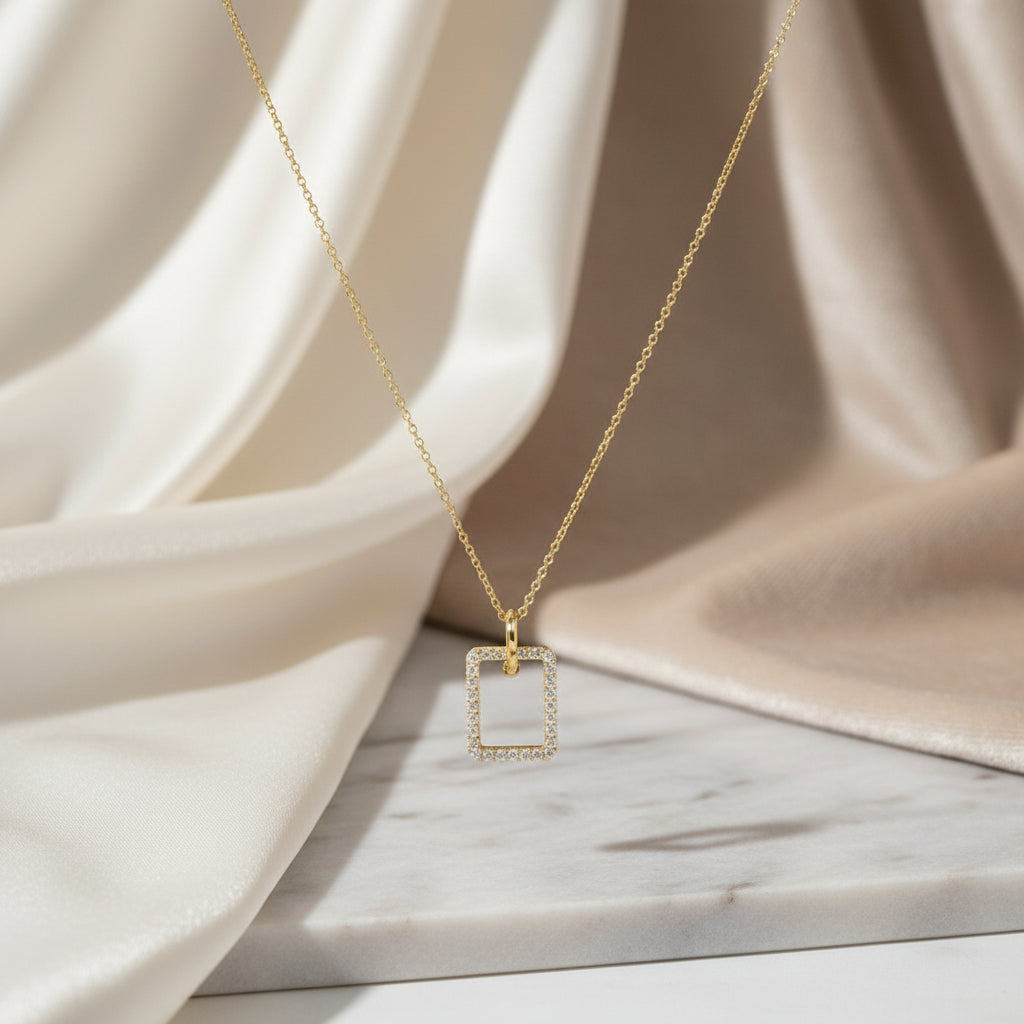 Goldkette mit frontal ausgerichtetem, rechteckigem Anhänger, vollständig mit funkelnden Zirkonia-Steinen besetzt.