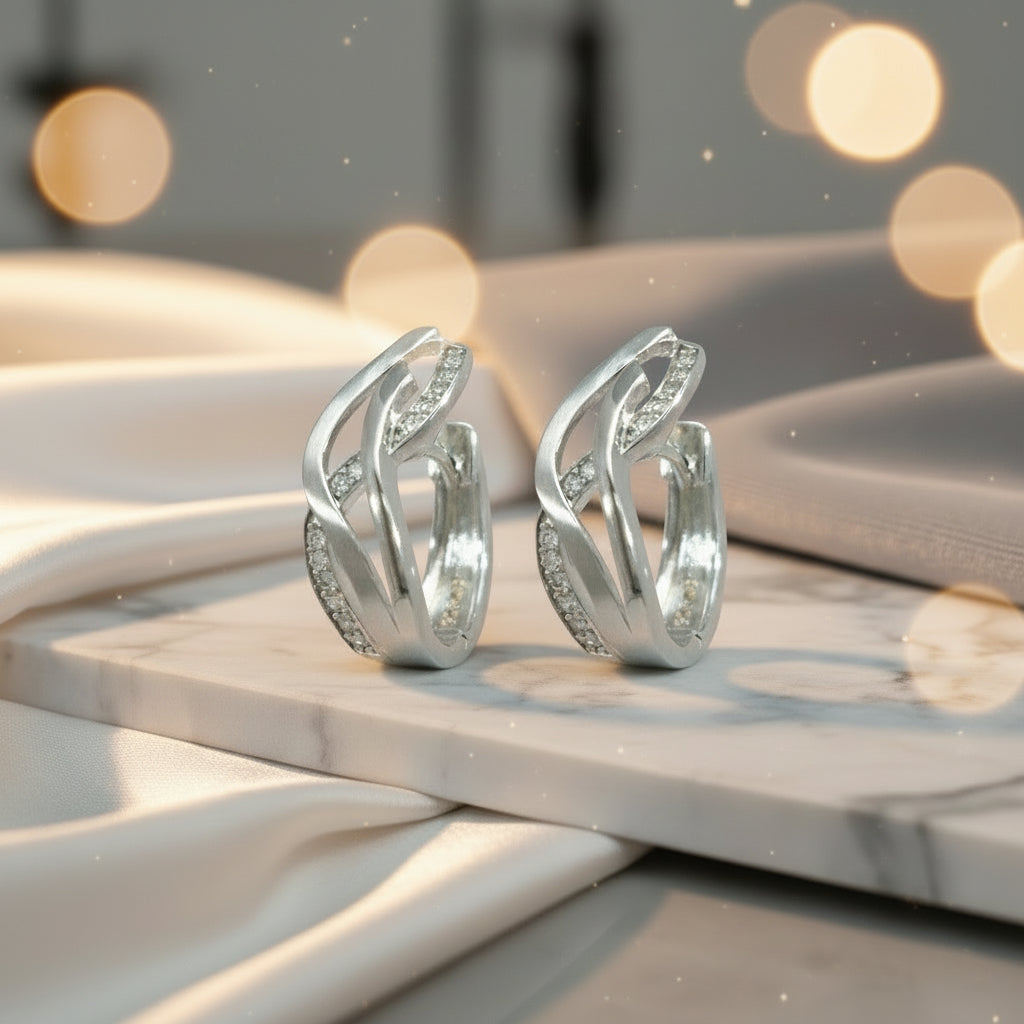 Splendido CRSU25 breite Silbercreolen aus rhodiniertem 925er Silber mit geschwungenen Zirkonia-Bändern.

